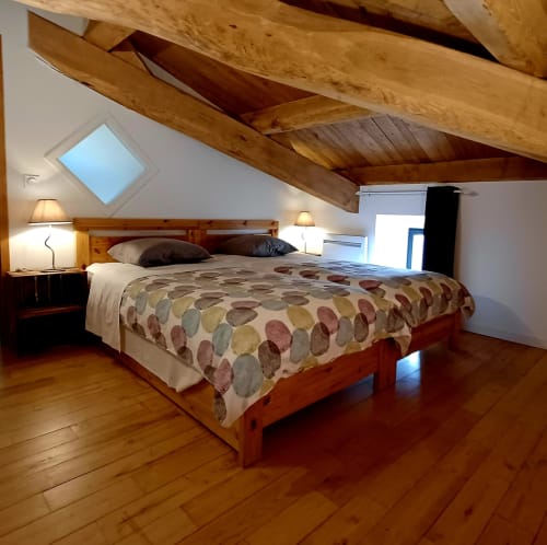 Chambre loft rustique avec poutres en bois, lit queen-size et lucarnes aux Gîtes Du Couvent, Ardèche