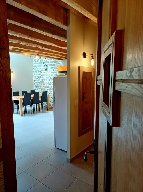 Entrée du couloir du gîte 4 aux Gîtes Du Couvent, Ardèche, avec salle à manger visible par la porte