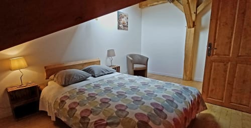 Chambre douillette aux Gîtes Du Couvent en Ardèche avec lit queen, poutres apparentes et coin salon