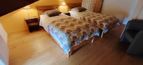 Chambre spacieuse aux Gîtes Du Couvent avec deux lits, parquets, lampes de chevet et ambiance chaleureuse en Ardèche