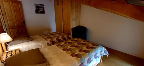 Chambre twin au Gîte 4 des Gîtes Du Couvent, Ardèche, avec poutres en bois et linge de lit à motifs