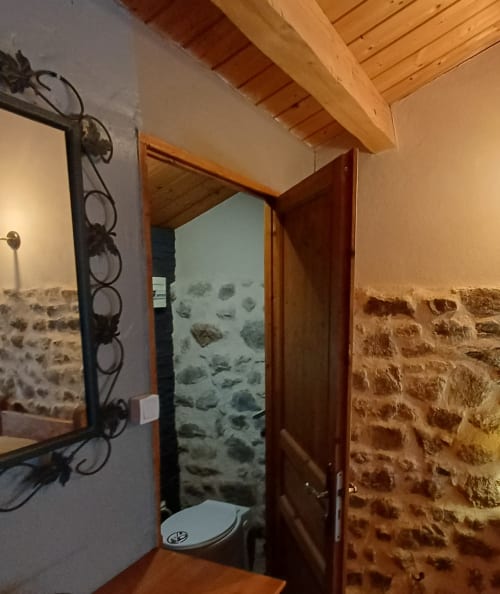 Porte d'entrée en pierre avec battant en bois aux Gîtes Du Couvent, gîte d'Ardèche à Nozières, France