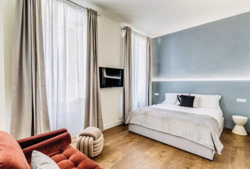 Camera moderna nell'appartamento Rome to You con letto queen, TV a schermo piatto, finestre da pavimento a soffitto e parete con accento blu