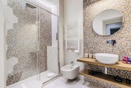 Moderno bagno dell'appartamento Rome to You con piastrelle decorate, lavabo bianco a ciotola, toilette, bidet e doccia a filo pavimento