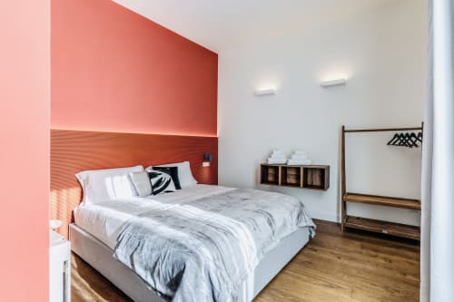 Camera moderna presso Rome to You B&B con parete d'accento rosa, letto in legno e arredi contemporanei a Monte Sacro