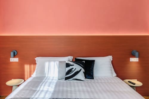 Camera da letto moderna dell'appartamento Rome to You con testata in terracotta texturizzata, biancheria bianca e luce naturale a Monte Sacro