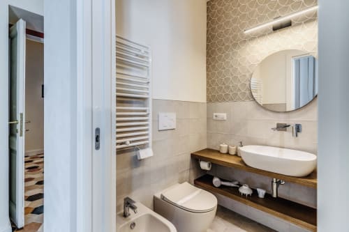 Bagno moderno nell'appartamento Rome to You con lavabo ovale bianco, scaldasalviette e specchio rotondo a Monte Sacro