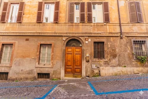 Facciata di edificio storico a Roma nel quartiere Monte Sacro con porta in legno e finestre con persiane