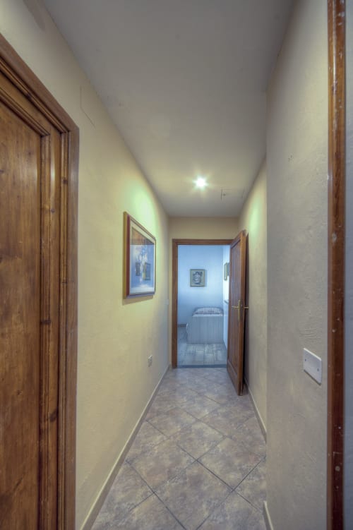 Bright hallway with wooden doors at Sogni D'Oro Guest House, Florence, leading to bedroom