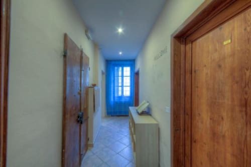 Bright hallway at Sogni D'Oro Guest House in Florence with wooden doors and blue entrance