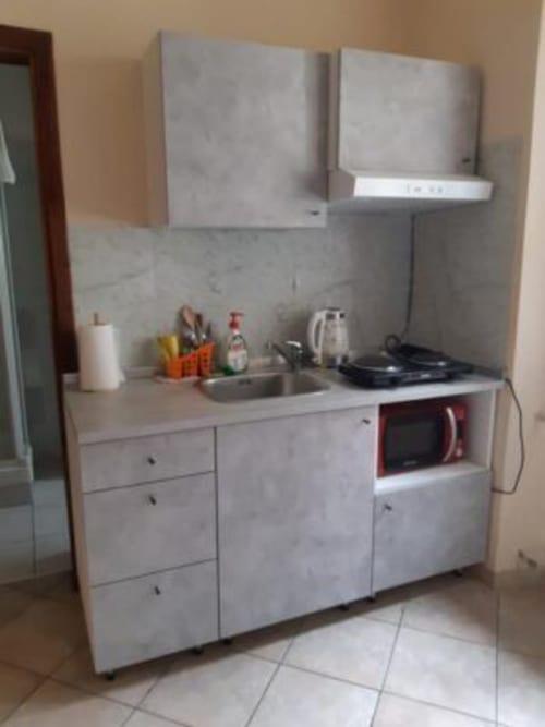 Compact kitchenette at Sogni D'Oro Guest House Florence with sink, microwave, and storage cabinets