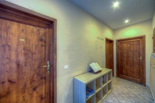 Sogni D'Oro Guest House hallway with wooden doors, storage shelves, and warm lighting in Florence