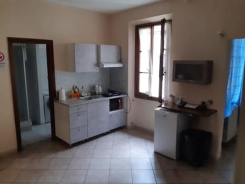 Bright kitchen area at Sogni D'Oro Guest House in Florence with white cabinetry, appliances, and glass doors opening to