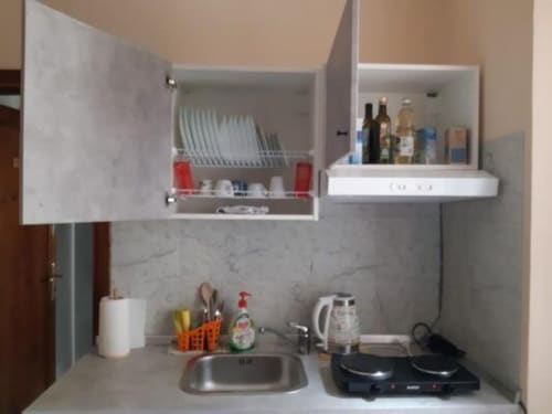 Angolo cottura compatto a Sogni D'Oro Guest House a Firenze con fornelli, lavello, armadi e accessori essenziali
