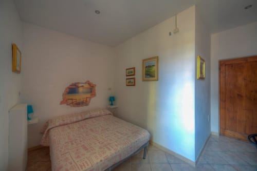 Camera luminosa della Sogni D'Oro Guest House a Firenze con letto singolo, porta in legno e quadri appesi