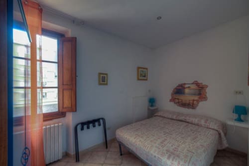 Camera luminosa a Sogni D'Oro Guest House a Firenze con letto singolo, persiane in legno e dettagli turchesi