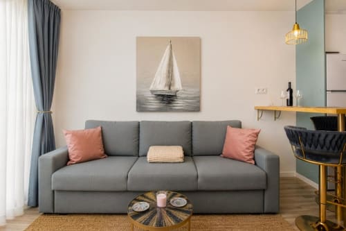 Sofá gris con cojines coral en la sala del apartamento Auramar de Smart Rent Fuerteventura, Tarajalejo