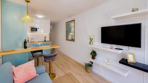 Moderno apartamento Auramar en Smart Rent Fuerteventura con salón abierto, cocina, comedor y televisor de pared