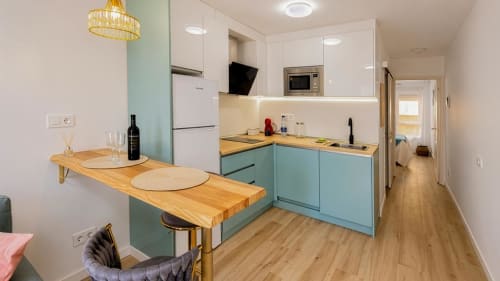 Cocina y comedor modernos del apartamento Auramar en Smart Rent Fuerteventura, con muebles turquesas y detalles en madera