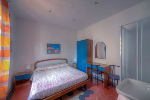 Camera da letto a Sogni D'Oro Guest House a Firenze con letto in legno, armadio blu e bagno privato