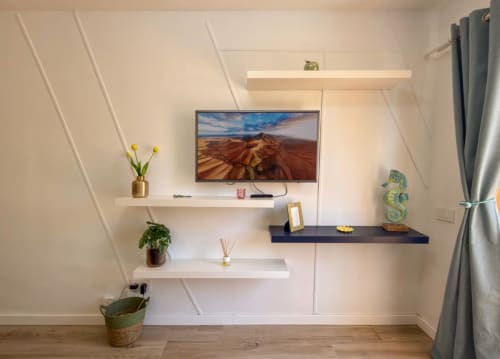 Moderno apartamento con TV montada, estantes flotantes y decoración minimalista en el hotel Smart Rent Fuerteventura