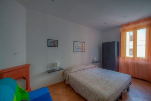 Camera spaziosa a Sogni D'Oro Guest House a Firenze con mobili in legno, pavimenti in terracotta e persiane arancioni