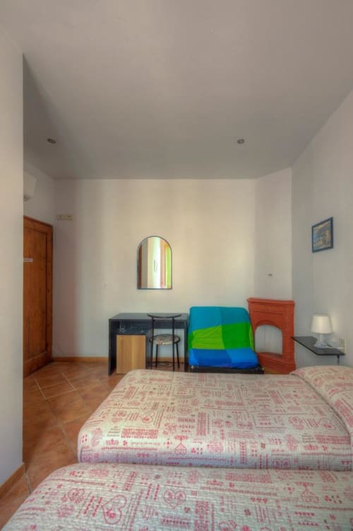Camera spaziosa a Sogni D'Oro Guest House a Firenze con letti, scrivania e colorati elementi di stoccaggio
