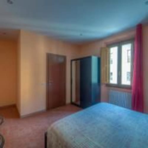Camera colorata alla Guest House Sogni D'Oro di Firenze con soffitto blu, pareti beige e accenti rosa
