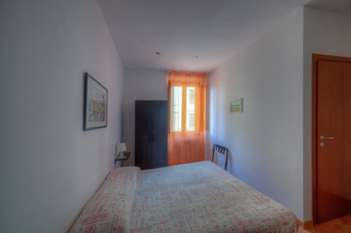 Camera luminosa nella Locanda Sogni D'Oro a Firenze con letto, armadio e porte con cornici arancioni