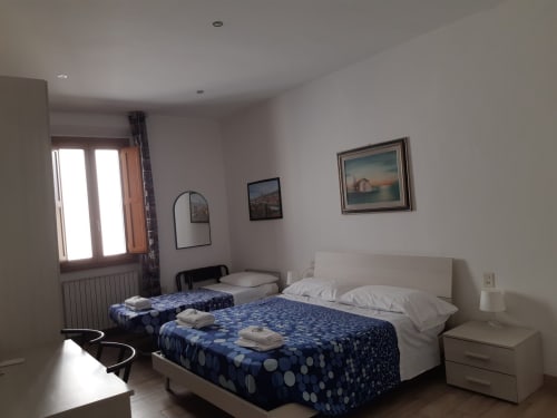 Camera luminosa con letti dalle fantasie blu, biancheria bianca e quadri alle pareti presso Sogni D'Oro Guest House a Firenze