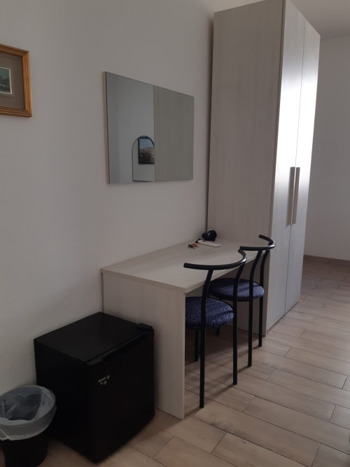 Camera ospiti minimalista presso Sogni D'Oro BnB a Firenze con scrivania, specchio e arredamento moderno