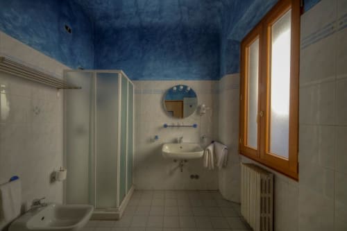 Bagno moderno della Sogni D'Oro Guest House a Firenze con soffitto blu, doccia, lavabo e finestra in legno