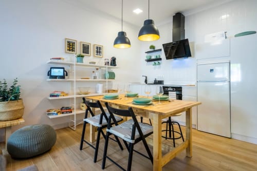 Cocina y comedor modernos en apartamento de Nerja con mesa de madera, sillas negras, lámparas colgantes y electrodomésticos blancos
