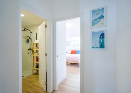 Baño moderno con ducha de obra en apartamento de Nerja en Apartamentos Minaga, con detalles en amarillo y estilo costero