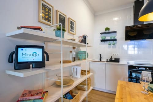 Cocina moderna del apartamento Minaga, Nerja, con estanterías abiertas, tablet, comedor y electrodomésticos integrados