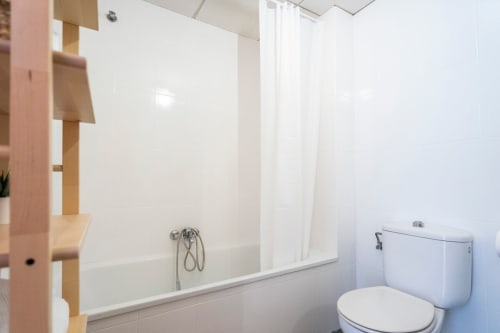 Baño moderno en apartamento de Nerja con bañera, cabina de ducha e inodoro en Apartamentos Minaga Calle Chaparil