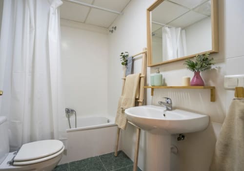 Baño moderno con lavamanos de pedestal, inodoro y bañera en Apartamentos Minaga en Nerja