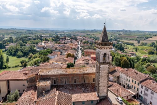 Aerial view of historic Montepulciano with terracotta roofs, bell tower, and rolling Tuscan countryside near Sogni D'Oro