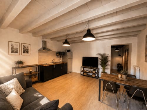 Modernes Apartment mit offener Grundfläche im Zentrum von Bergamo mit Balkendecken, schwarzer Küche, Holzboden und Wohnbereich