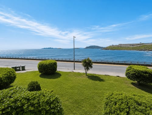 Jardín diseñado con vista al mar sobre la costa de Baiona, apartamento As Estelas con terraza y paisajismo