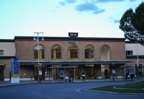 Modern train station building in Ravenna, Italy with brick facade and arched windows
