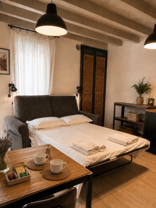 Modernes Studio-Apartment in Bergamo mit Schlafsofa, Holzmöbeln, Pendelleuchten und kostenlosem Kaffee-Setup.