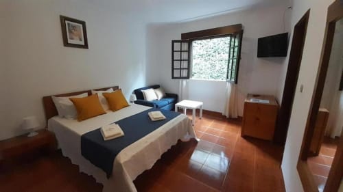 Quarto Triplo Standard na Pousada Serrana Gerês em Gerês, Portugal com cama, TV e piso em azulejo