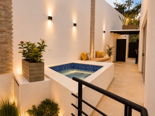 Suite Deluxe La Masia Hotel Boutique con Jacuzzi privado, patio iluminado al atardecer, piscina de azulejos azules y vistas al jardín