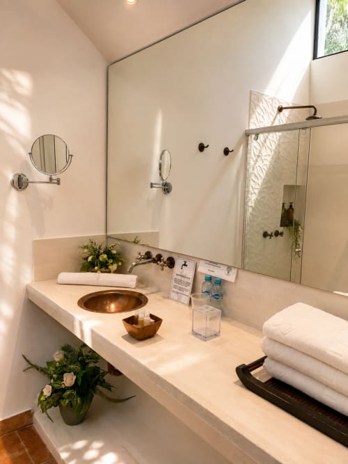 Baño de lujo en La Masia Hotel Boutique con tocador de mármol, lavamanos tipo vasija y espejo con vista al jardín