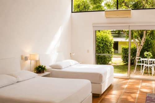 Luminosa habitación superior doble en La Masia Hotel Boutique con dos camas, vistas al jardín y acceso a terraza en Anapoima