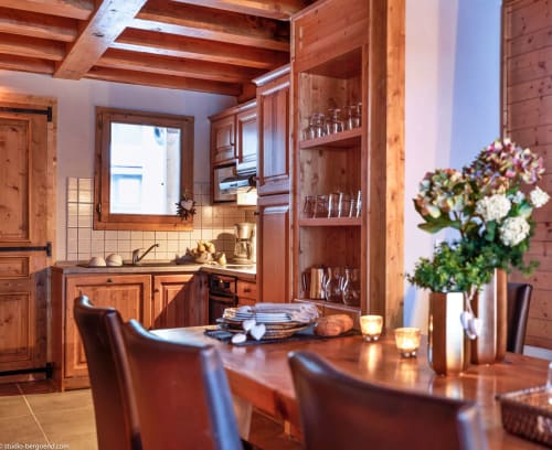 Salle à manger-cuisine alpine rustique avec cheminée, vue montagne et bouquet de fleurs aux Étoiles de
