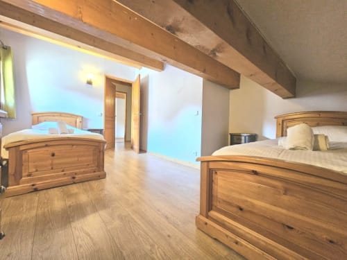 Chambre spacieuse d'appartement montagnard avec lits en bois et poutres aux Étoiles de la Plagne, La Plagne-Tarentaise