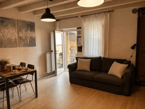 Modernes Wohnzimmer in Bergamo mit schwarzem Sofa, Esstisch und Balkonzugang