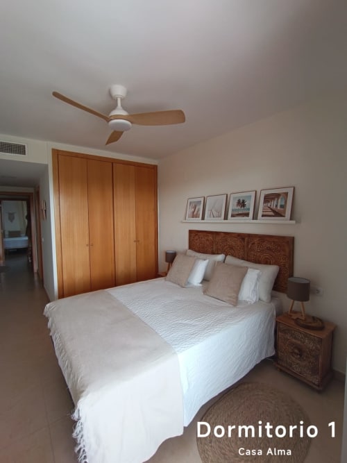 Spacieuse chambre principale de l'appartement Casa Alma à Sant Jordi, avec lit queen-size et tête de lit en bois décorée